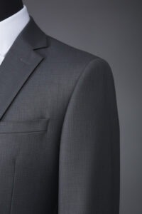 Dark grey slim-fit notch lapel men’s suit paired with a crisp white dress shirt, tailored for a gentlemen