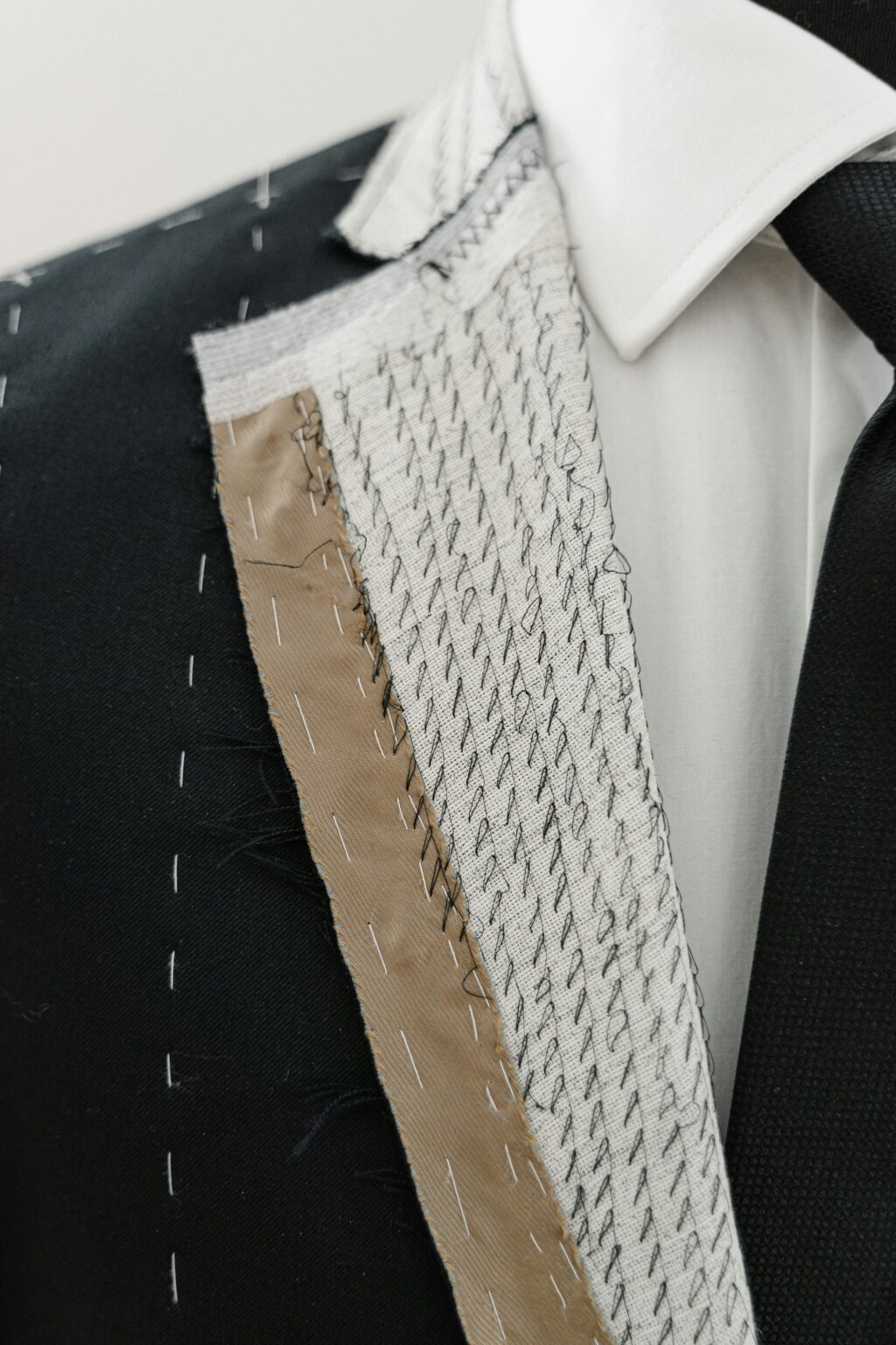 Black full-canvas suit jacket showing hand-stitched internal canvas, fabric