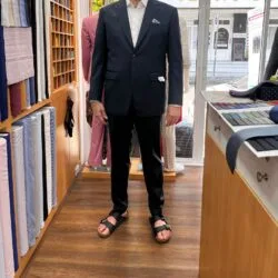 Customer wearing a navy custom wedding suit with a white dress shirt at a bespoke tailor in Sukhumvit 33, Bangkok