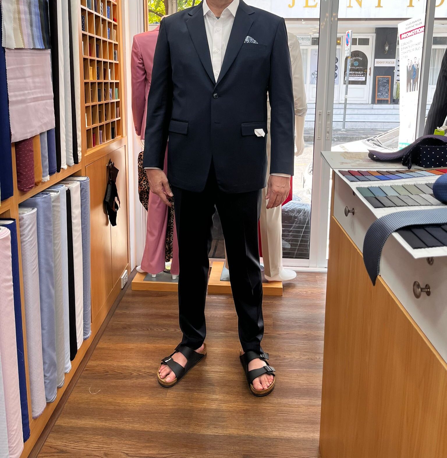 Customer wearing a navy custom wedding suit with a white dress shirt at a bespoke tailor in Sukhumvit 33, Bangkok