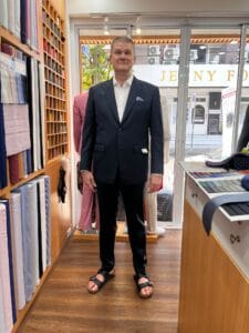 Customer wearing a navy custom wedding suit with a white dress shirt at a bespoke tailor in Sukhumvit 33, Bangkok